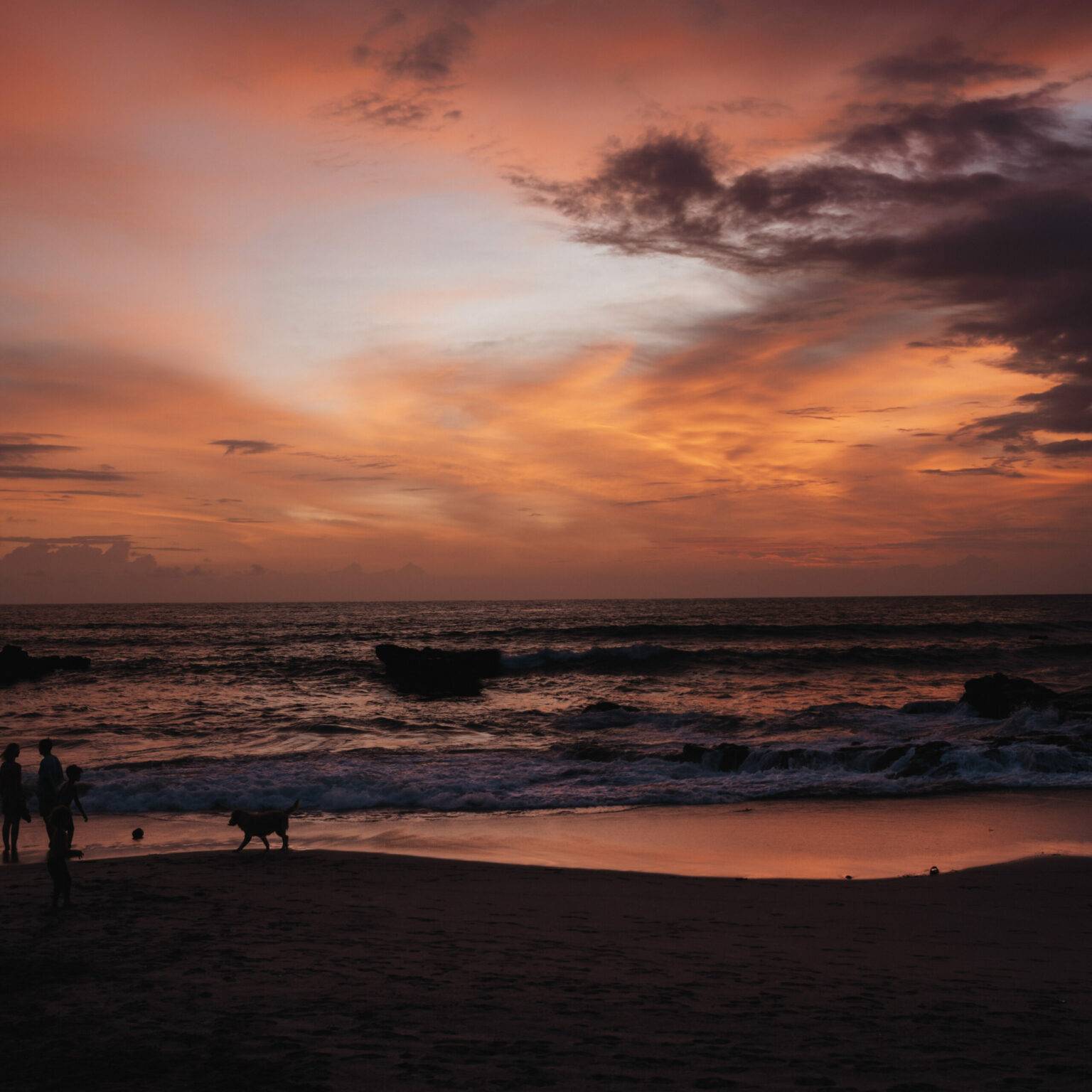 Rot-orangener Sonnenuntergang am Strand von Canggu, Bali.